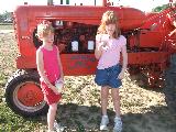 Kayla and Kelly standing in front of the Cooprider tractor